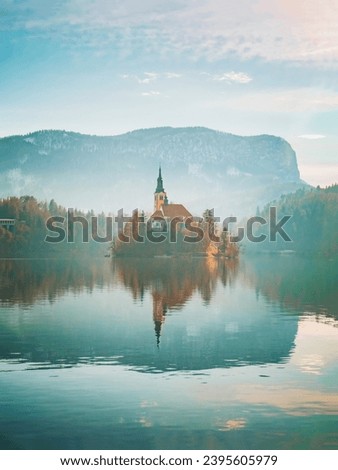 A living picture of serenity, with a blue lake embracing a picturesque church and the majestic mountains as a backdrop.
