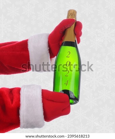 Santa Claus outstretched arms holding a Champagne Bottle in both hands embossed with the year 2024. Vertical with a snowflake background.