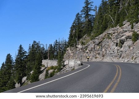 Bikers struggle the uphill climb on Rim Drive in Crater Lake National Park.  They are riding the curvy road around Crater Lake.