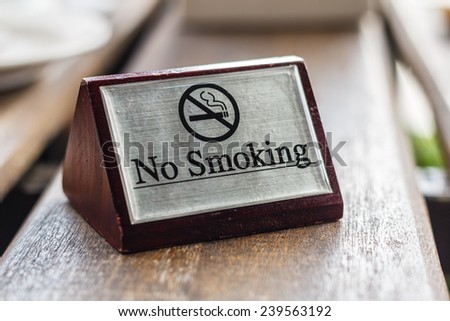 no smoking sign on wood dining table in restaurant
