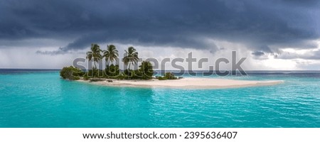 Small Maldivian Desert Island on Risk Due to Sea Level Rising with a Lagoon, lush Vegetation, and Three Coconut Palm Trees Moments before a Monsoon Tropical Storm struck on it.   Royalty-Free Stock Photo #2395636407