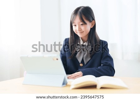asian elementary school girl studying with tablet in classroom Royalty-Free Stock Photo #2395647575