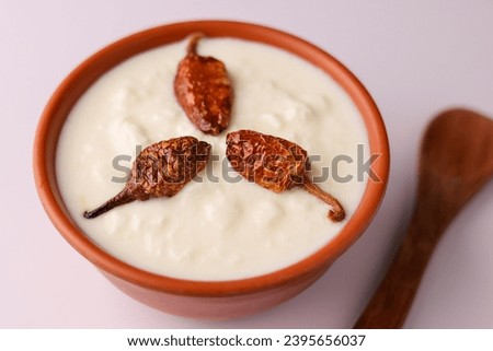 Bowl of homemade sour cream curd yogurt Dahi fresh herbs curry leaf Kerala India. Dairy product obtained coagulating milk process curdling. probiotic food tasty curd rice curry spices Royalty-Free Stock Photo #2395656037