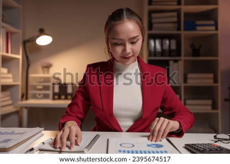 Asian businesswoman doing report, analysis, bill calculation, balance sheet review with company quarterly report. document balance Financial planning, investing, analytical concepts business audit.