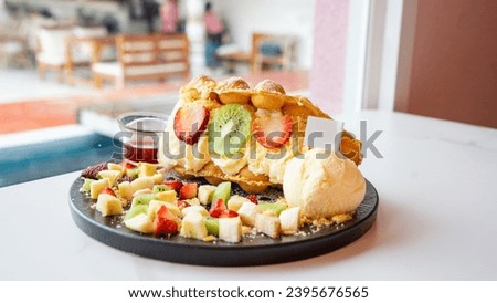 Dessert menu with fruits and ice cream as main ingredients. There is sauce to add later. Put on a round flat plate. beautifully decorated Located in the middle of a white table, it 