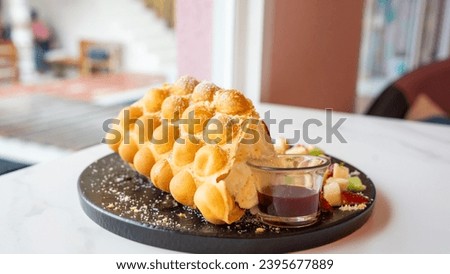 Freshly baked bread with unique shapes in the dessert menu. Add toppings with citrus fruits. Paired with ice cream Located in the middle of a white table. It's a close-up focus photo with distant blur