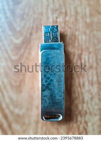 USB flash drive with a metallic casing and Wood table background 