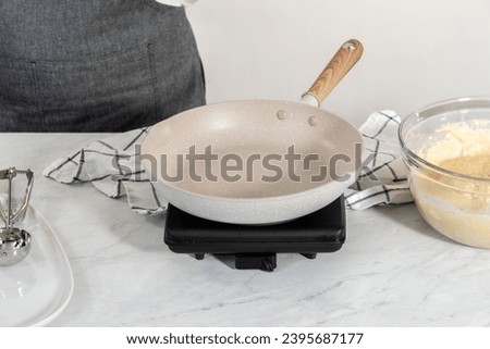 Preparing eggnog pancakes in a nonstick frying pan. Royalty-Free Stock Photo #2395687177