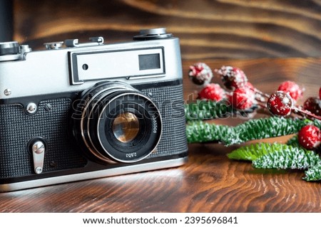 Vintage film camera and film, Christmas tree branch with ornaments on wooden background