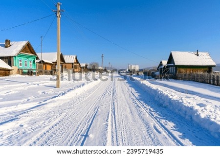 Russian snowy village in winter. Ural Mountains, Russia. Royalty-Free Stock Photo #2395719435