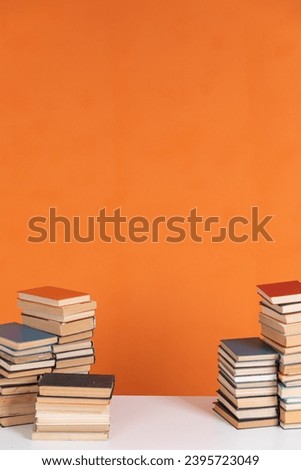 Lots of stacks of old educational books on orange background University School Library