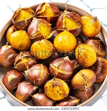 A bowl filled with peeled chestnuts on top of a table. Beautiful picture of Roasted Chestnuts.