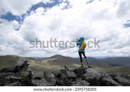 Woman photographer taking photo on mountain top
