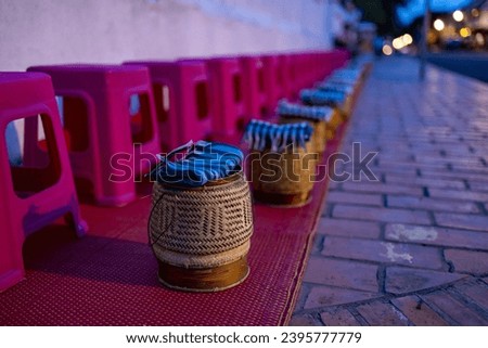 Buddhist alms giving ceremony in the early morning.Monks walk to collect alms and offerings.Sticky rice morning alms giving is held every day in Luang Prabang.Traditional ritual of alms giving in Laos Royalty-Free Stock Photo #2395777779