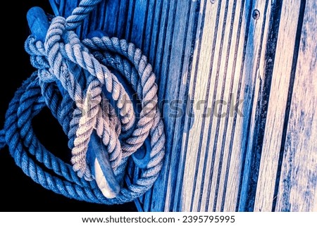 close up of yacht or boat mooring rope tied around cleat in harbour Royalty-Free Stock Photo #2395795995