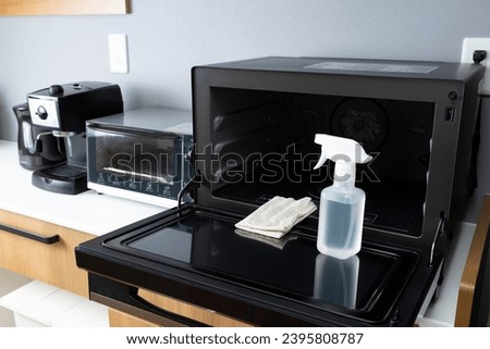 Clean the microwave with detergent. Royalty-Free Stock Photo #2395808787
