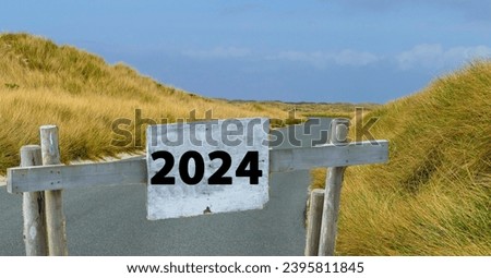 Sign with Year 2024 in Front of Road Royalty-Free Stock Photo #2395811845