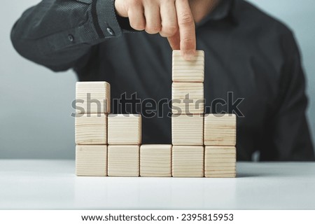 Hand putting and stacking blank wooden cubes on table with copy space for input wording or infographic icon.