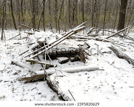 The remains of a forester's house in the middle of the forest under a thick layer of snow. A wooden house in ruins. A pile of wooden structures lies in the forest covered with snow. Royalty-Free Stock Photo #2395820629