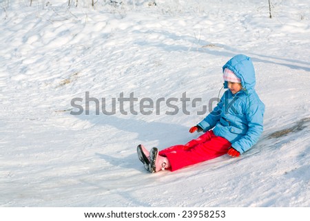 Small girl in winter snow covered courtyard