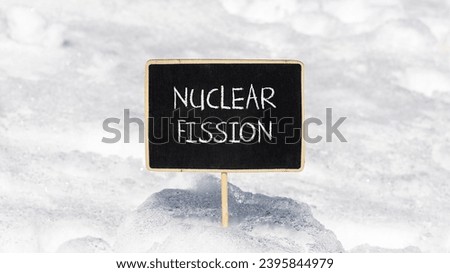 Nuclear fission symbol. Concept words Nuclear fission on beautiful black chalk blackboard. Chalkboard. Beautiful snow background. Business science nuclear fission concept. Copy space. Royalty-Free Stock Photo #2395844979