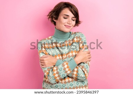 Portrait of attractive young girl wearing ornament stylish sweater hugs herself close eyes comfortable isolated on pink color background Royalty-Free Stock Photo #2395846397