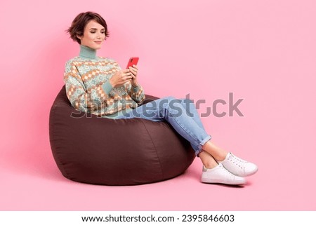 Full body photo of sitting comfortable brown pouf event location zone order taxi smartphone app advert isolated on pink color background