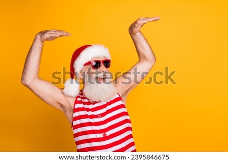 Photo of crazy funky senior guy dressed christmas swimwear hat glasses enjoy discotheque empty space isolated yellow color background