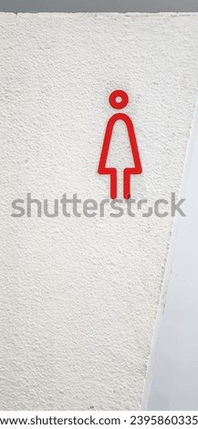 public toilet sign board with red woman figure on white background or surface.