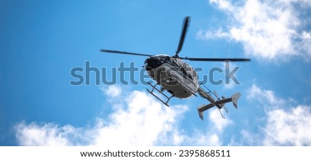 Helicopter close-up against the sky. Rescue helicopter flies in the sky with clouds. Royalty-Free Stock Photo #2395868511