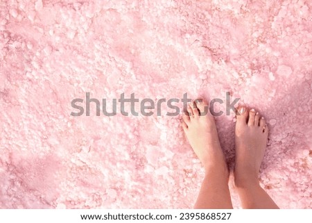 Pink lake. Girl's feet on water with pink salt. A unique rare natural phenomenon. Salt Lake. Royalty-Free Stock Photo #2395868527