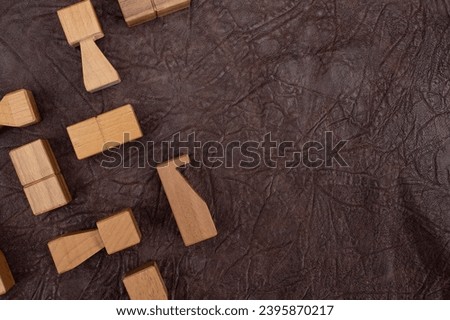 Minimal wooden chess pieces on textured brown leather background, with copy space