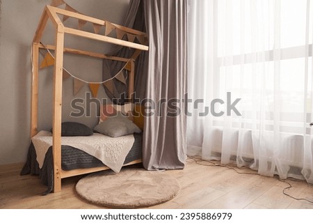 A child's bed made of wood in the shape of a house. The concept of arranging a children's room with space for copying. High quality photo