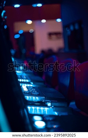 Dark-themed casino featuring slot machines with flashing buttons and ambient lights