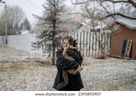 Young Girl in Jacket Outside Finds and Hugs Big Fluffy Siamese Cat in Yard Smiling