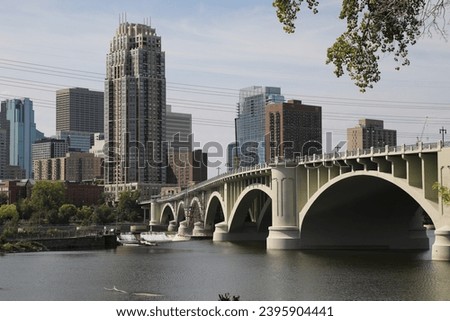 The Beautiful Minneapolis Skyline and bridge hovering over the calm waters of  Mississippi river