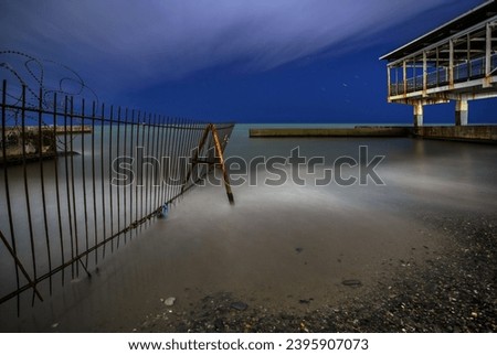 Night on a pebble beach with a pier, long exposure photography. Sochi, Russia