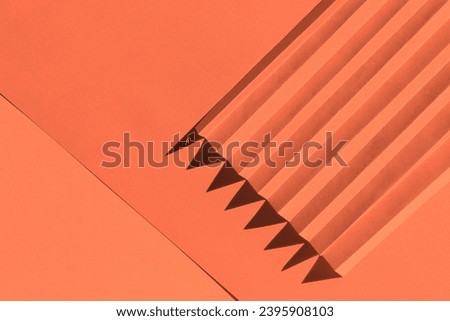 Apricot crush color of the year 2024. Folded paper with harsh sun shadows, geometric shapes and lines 3D texture. 