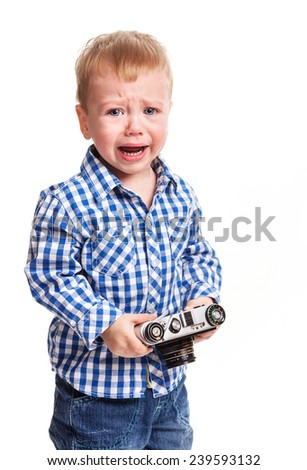 Toddler boy holding camera and crying