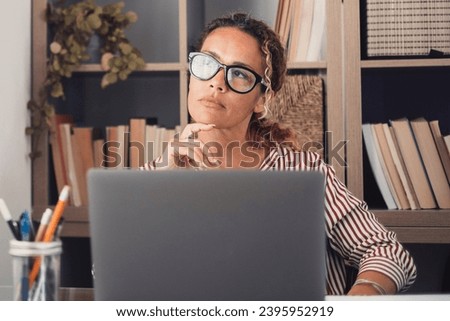 Caucasian reflexive looking at laptop screen, reflexing on work, businesswoman independent working in a difficult project. Female person preparing at home in the office indoor. Royalty-Free Stock Photo #2395952919