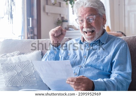 Excited elderly man celebrate health insurance deal closing looking and reading the medical results. Happy mature senior feel overjoyed make sign good bank agreement with specialist. Checking outcomes