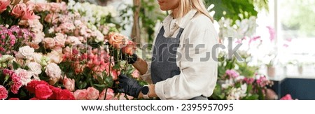 Woman florist flower shop owner hold roses on floral background. High quality photo Royalty-Free Stock Photo #2395957095