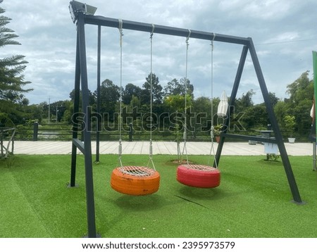 Chingcha (a traditional Thai swing) leisurely swaying in a garden cafe, providing a serene and playful atmosphere. Royalty-Free Stock Photo #2395973579