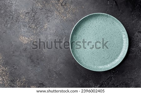 Empty rustic green classic plate over Dark rough table surface . top view, with copy space. top table setting. for menu, layout, place for text , recipe background, food flat lay Royalty-Free Stock Photo #2396002405