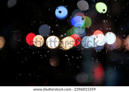 Image of raindrops on the window at night in the city, burry background, abstract bokeh, for background