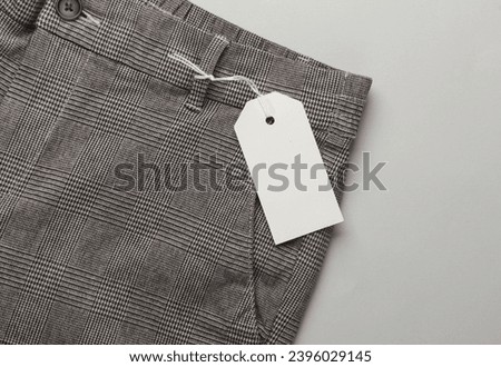 Trousers with white blank tag. Shopping, sale concept. Template for design