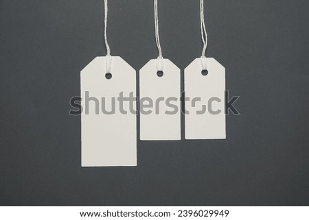 Blank white tags with ropes on dark gray background. Mock up, Template for design. Copy space. Sale, shopping concept