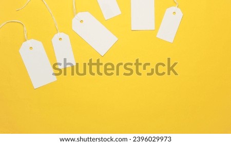 Blank white tags with ropes on yellow background. Mock up, Template for design. Copy space. Sale, shopping concept