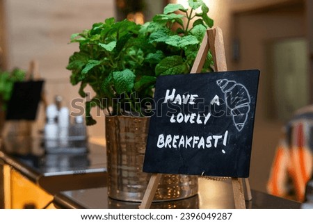 Inviting Breakfast Buffet Sign Amidst Fresh Herbs Encouraging Guests to Enjoy Meal in hotel