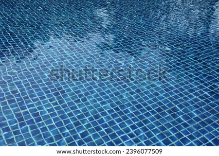 exterio pgoto view of the surface of a blue swimming pool in a resort hotel or a public sport center centre wit hthe blue turquoise tiles with still water during the day of spring or summer